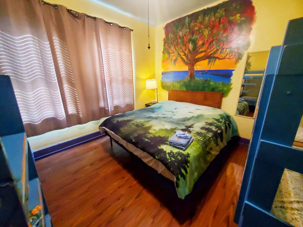 The Tree Room, Room 7, showing the king bed and a tree mural.